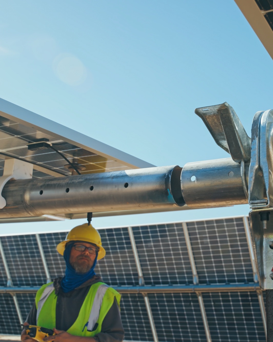 A crew member monitors equipment beneath a solar bay.
